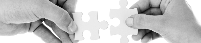 Hands joining puzzle pieces together