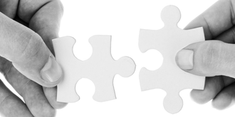 Hands joining puzzle pieces together